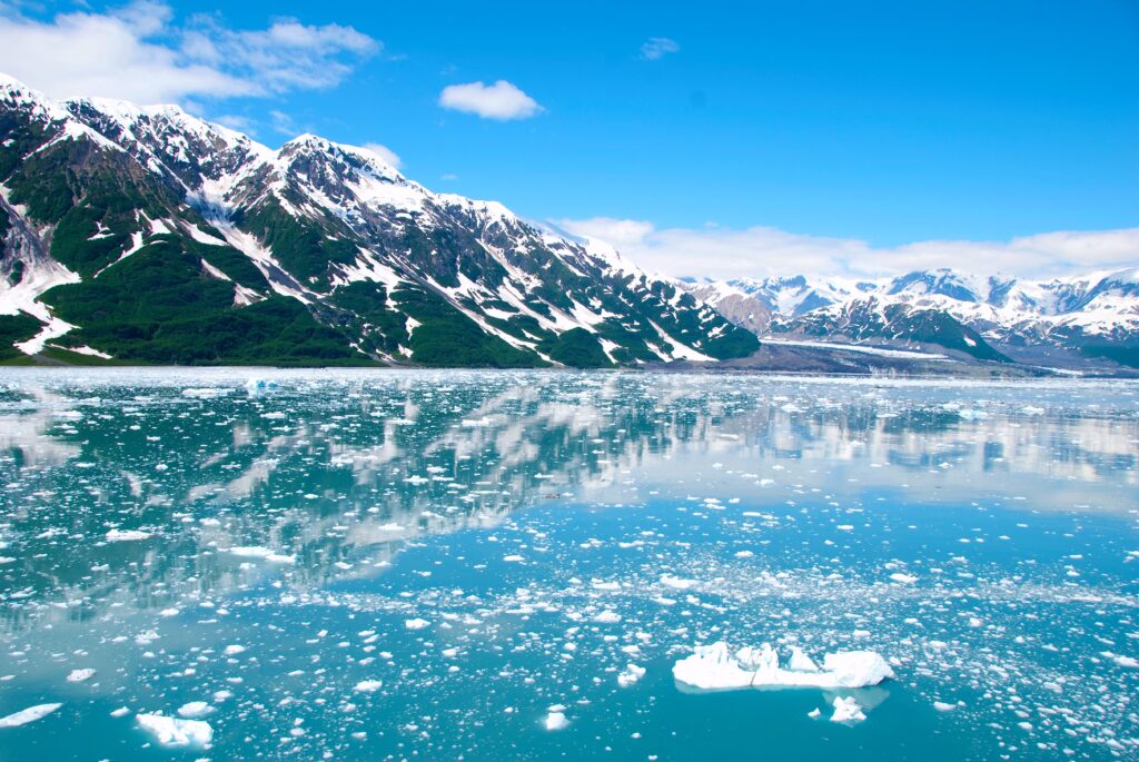 mountains half covered in snow and alaska sea